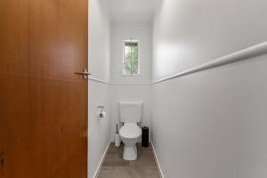 a bathroom with a toilet and a window at Tranquil Hideaway - Lake Okareka Holiday Home in Lake Tarawera +13 photos