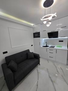 Una sala de estar con un sofá y una cocina. en Blue sky, en Itʼkhvisi 1 foto más