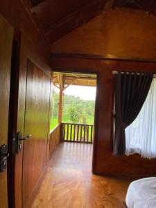 a room with a door open to a balcony at Bareng Homestay Tetebatu in Tetebatu