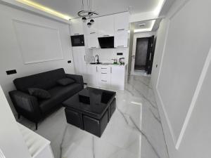 Una sala de estar con un sofá negro y una mesa. en Blue sky, en Itʼkhvisi