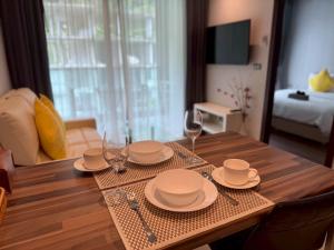 a dining room table with plates and wine glasses at Emerald Terrace Resort 622 in Patong Beach