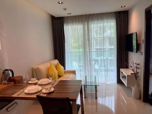 a living room with a couch and a table at Emerald Terrace Resort 622 in Patong Beach