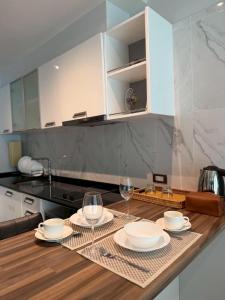 a kitchen with a table with plates and wine glasses at Emerald Terrace Resort 622 in Patong Beach