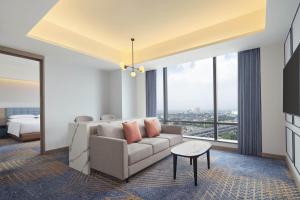 a living room with a couch and a bed at Four Points by Sheraton Bekasi in Bekasi
