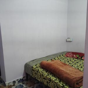 マトゥラーにあるGaurangi Mathura dharamshalaの毛布が付いた部屋のベッド1台