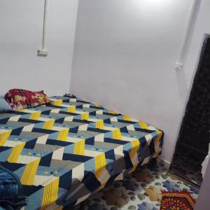 マトゥラーにあるGaurangi Mathura dharamshalaの青と黄色の部屋のベッド1台