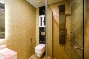 a bathroom with a toilet and a shower at Qinwan Hotel & Suites in Rawalpindi