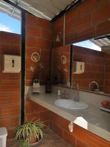 un baño con lavabo y espejo en Hosteria Florecer, en Piñas