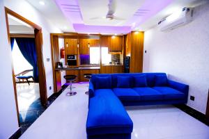 a living room with a blue couch in a room at Qinwan Hotel & Suites in Rawalpindi