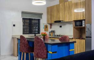 a kitchen with a blue island with bar chairs at Rhema Apartments in Lagos