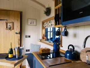 a kitchen with a sink and a stove top oven at Lillie's Shepherds Hut at Shepherds Lodge Retreat and Wellness in Nottingham +45 photos