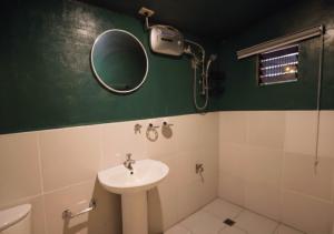 a bathroom with a sink and a mirror at Ocean Breeze Hostel by Daily Sweet in Moalboal +39 photos