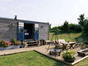 a tiny house with a picnic table and a patio at Lillie's Shepherds Hut at Shepherds Lodge Retreat and Wellness in Nottingham