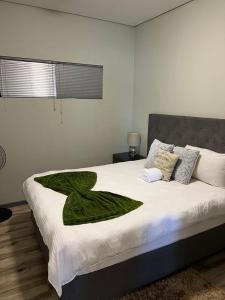 een bed met een groene deken erop bij Le grand hideout in Windhoek +3 foto's
