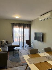 een woonkamer met een bank en een tv bij Le grand hideout in Windhoek