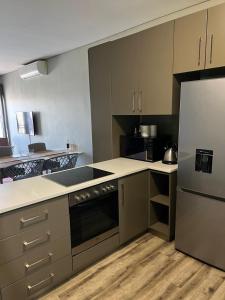 een keuken met een fornuis en een koelkast bij Le grand hideout in Windhoek