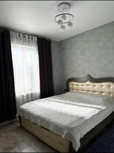 een slaapkamer met een bed en een raam bij TaTa Guest House in Bisjkek