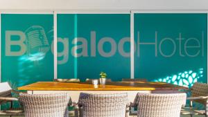 einen Tisch und Stühle vor einer grünen Wand in der Unterkunft Hotel Boogaloo - Adults Only in El Arenal