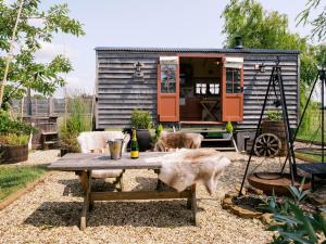 a tiny house with two dogs sitting on a table at Bonnie's Shepherds Hut at Shepherds Lodge Retreat and Wellness in Nottingham