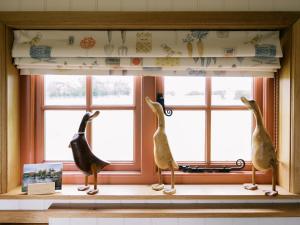 two birds statues sitting on a window sill at Bonnie's Shepherds Hut at Shepherds Lodge Retreat and Wellness in Nottingham