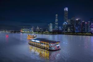 ein Boot in einem Fluss mit einer Stadt in der Nacht in der Unterkunft Yushe International Hotel - Pazhou Convention and Exhibition Center, Haizhu District, Guangzhou - Exclusive for the Canton Fair in Guangzhou