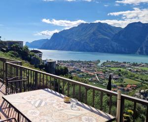 a table on a balcony with a view of a lake at Appartamenti Nido d'Aquila - Garda Lake View in Nago-Torbole