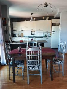 a kitchen with a table and chairs and a kitchen with a refrigerator at Acogedor apartamento en Noreña in Noreña