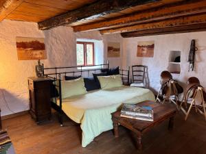 a bedroom with a bed and a table in a room at Cascina Pian dei Grilli, un paradiso nel Parco delle Capanne di Marcarolo in Casaleggio Boiro