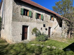 an old stone building with green shuttered windows at Cascina Pian dei Grilli, un paradiso nel Parco delle Capanne di Marcarolo in Casaleggio Boiro +30 photos