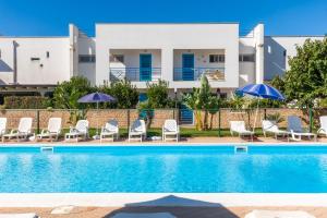 a villa with a swimming pool in front of a house at Dimora Riva Serena con Piscina in Torre Lapillo