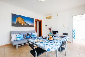a dining room with a table and a couch at Dimora Riva Serena con Piscina in Torre Lapillo