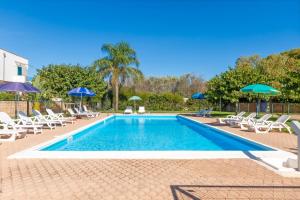 a swimming pool with chairs and umbrellas at Dimora Riva Serena con Piscina in Torre Lapillo