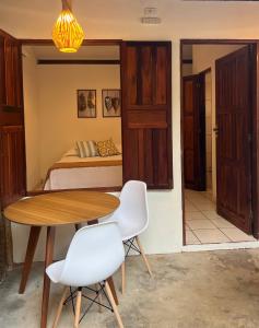 ein Schlafzimmer mit einem Bett und einem Tisch und Stühlen in der Unterkunft chalé coração da vila Caraíva in Porto Seguro
