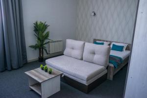 a living room with a couch and a table at Tarlan Hotel in Aktau