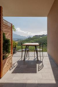 a table and chairs on a patio with a view at Apartment with terrace - Monte Ponente in Tassullo