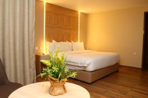 a hotel room with a bed and a table with a plant at Ailana Hotel in Aqaba