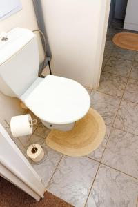 a bathroom with a white toilet sitting on a tiled floor at Apartmán MONTARA 23 in Donovaly