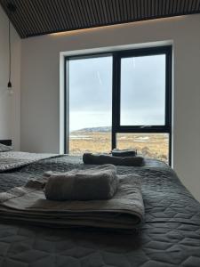 a bedroom with a bed with towels on it at LL Properties - Aurora Lodges in Grímsnes og Grafningshreppur
