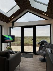 a living room with a large glass window at LL Properties - Aurora Lodges in Grímsnes og Grafningshreppur