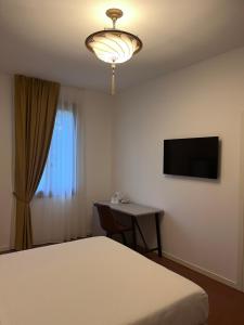 a bedroom with a bed and a desk and a television at Casanova Hideaway in Venice