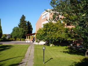 a house with a lawn in front of a building at Oasi Santa Rosa in Rome