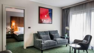 a living room with a couch and a bed at NH Brussels EU Berlaymont in Brussels