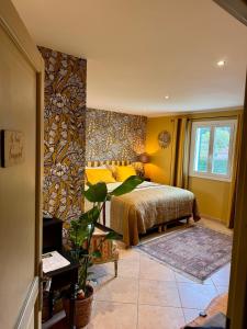 a bedroom with a bed with yellow pillows at La Bastide des Romarins in Plan-dʼOrgon
