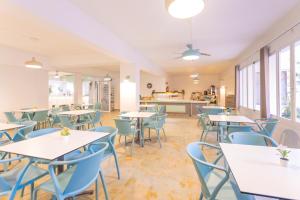 an empty cafeteria with tables and blue chairs at Hotel Boogaloo - Adults Only in El Arenal