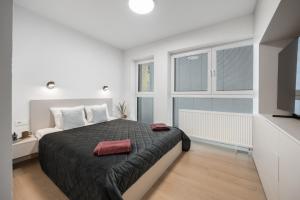 a bedroom with a large bed and two windows at LAM Cream Old Town Balcony & AC in Bratislava