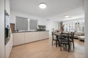 a kitchen and living room with a table and chairs at LAM Cream Old Town Balcony & AC in Bratislava