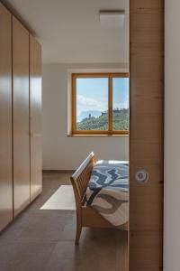 une chambre avec un lit et une fenêtre dans l'établissement Apartment with terrace - Monte Ponente, à Tassullo