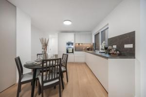 a kitchen and dining room with a table and chairs at LAM Cream Old Town Balcony & AC in Bratislava