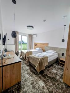 a hotel room with two beds and a sink at Hotel Eden in Rzgów