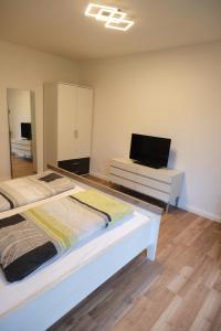a bedroom with two beds and a flat screen tv at Panoramablick vom Rodenberg in Rodenberg